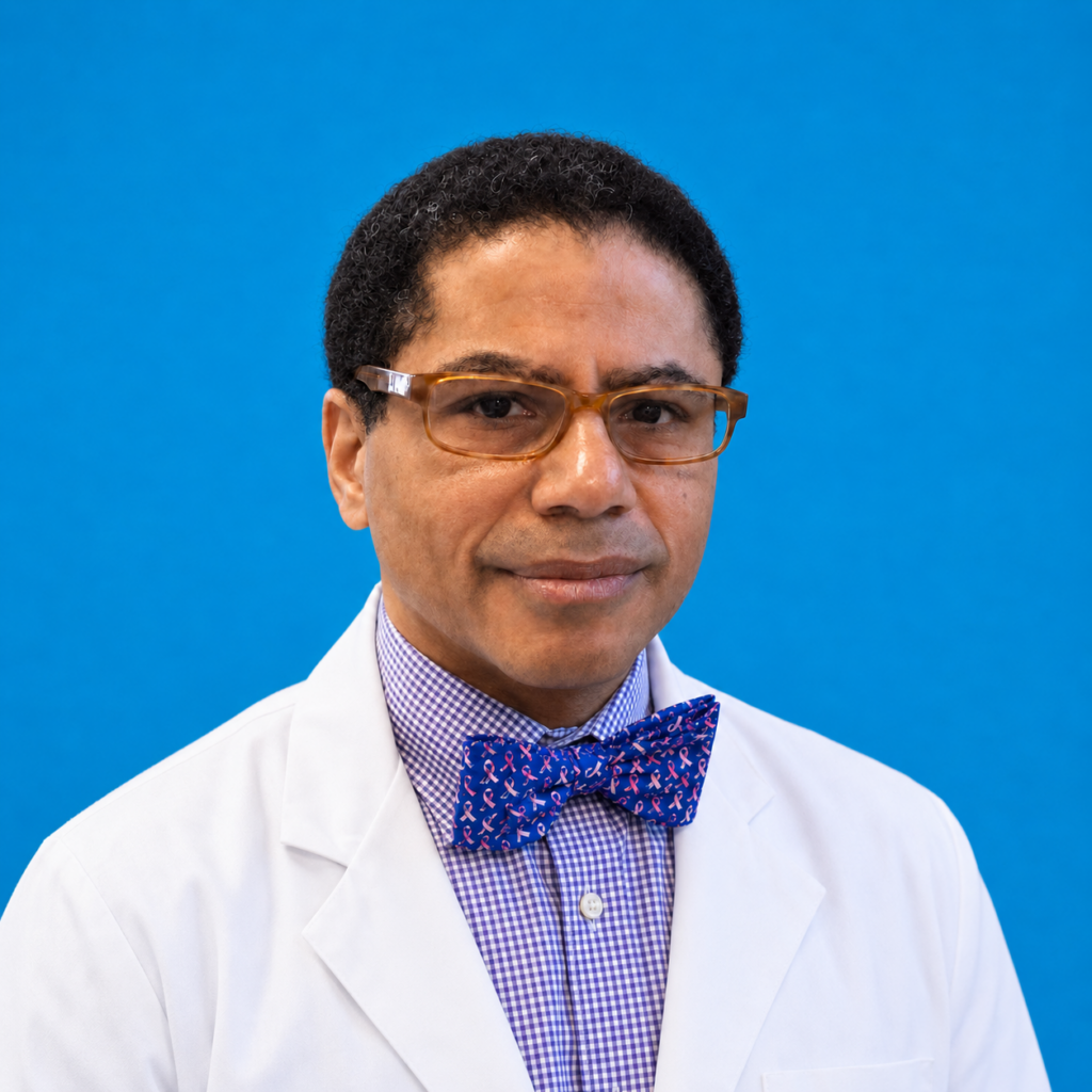 A man wearing glasses, a white lab coat, and a blue patterned bow tie poses against a bright blue background.